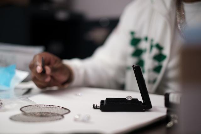 dillon-wanner-ayp0K7cAP68-unsplash Diamant in Etui auf einem Tisch mit verschwommener Person im Hintergrund